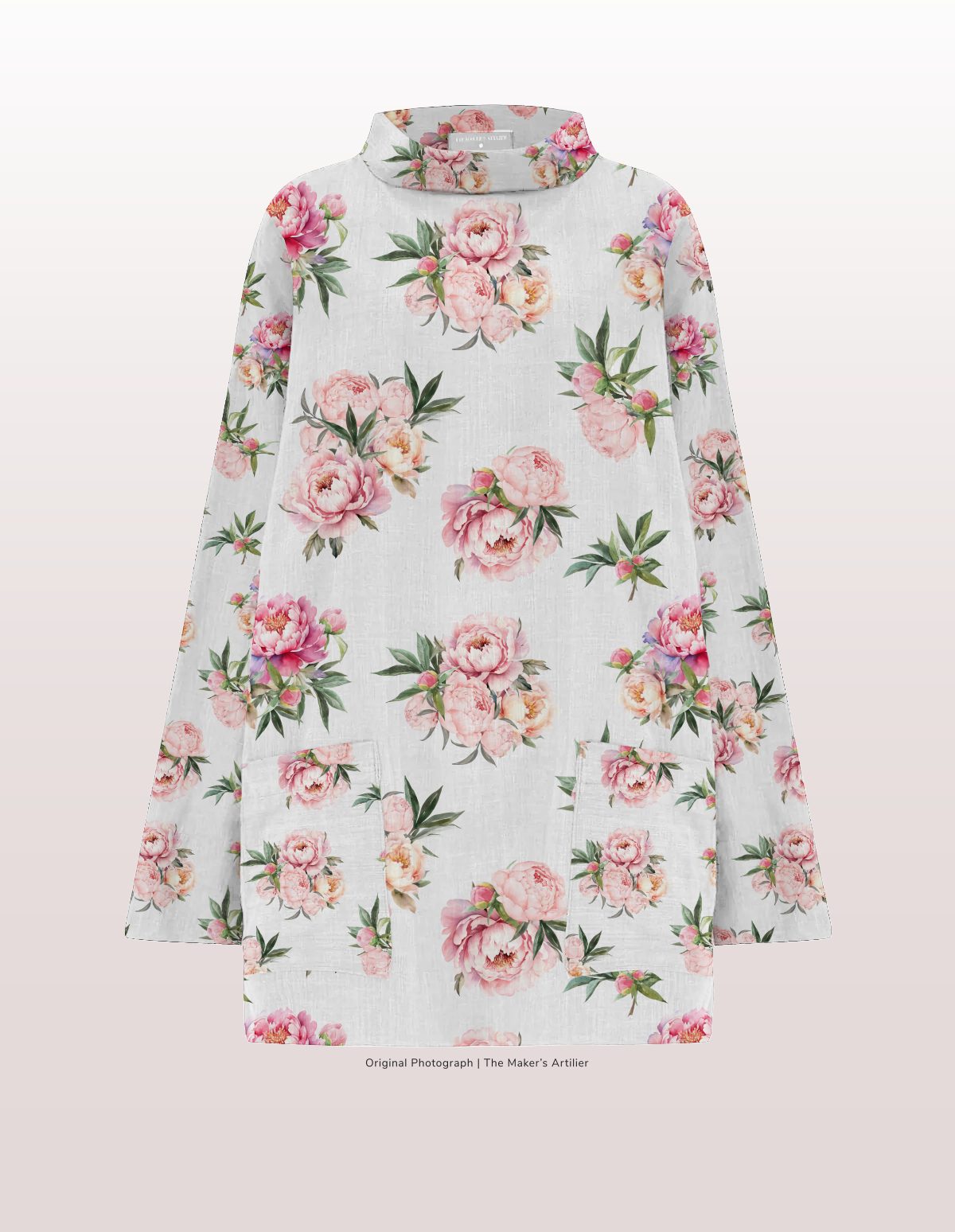 An image of a floral print smock/tunic top. Natural linen printed with pretty pink peonies. The top has a traditional stand up round collar and two front patch pockets.
