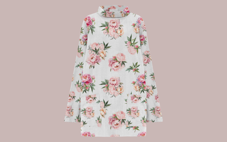An image of a floral print smock/tunic top. Natural linen printed with pretty pink peonies. The top has a traditional stand up round collar and two front patch pockets.