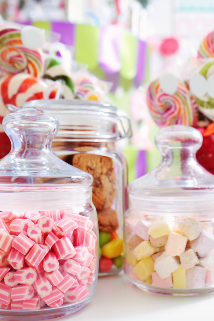 An image of an assortment of jars filled with candy, sweets.