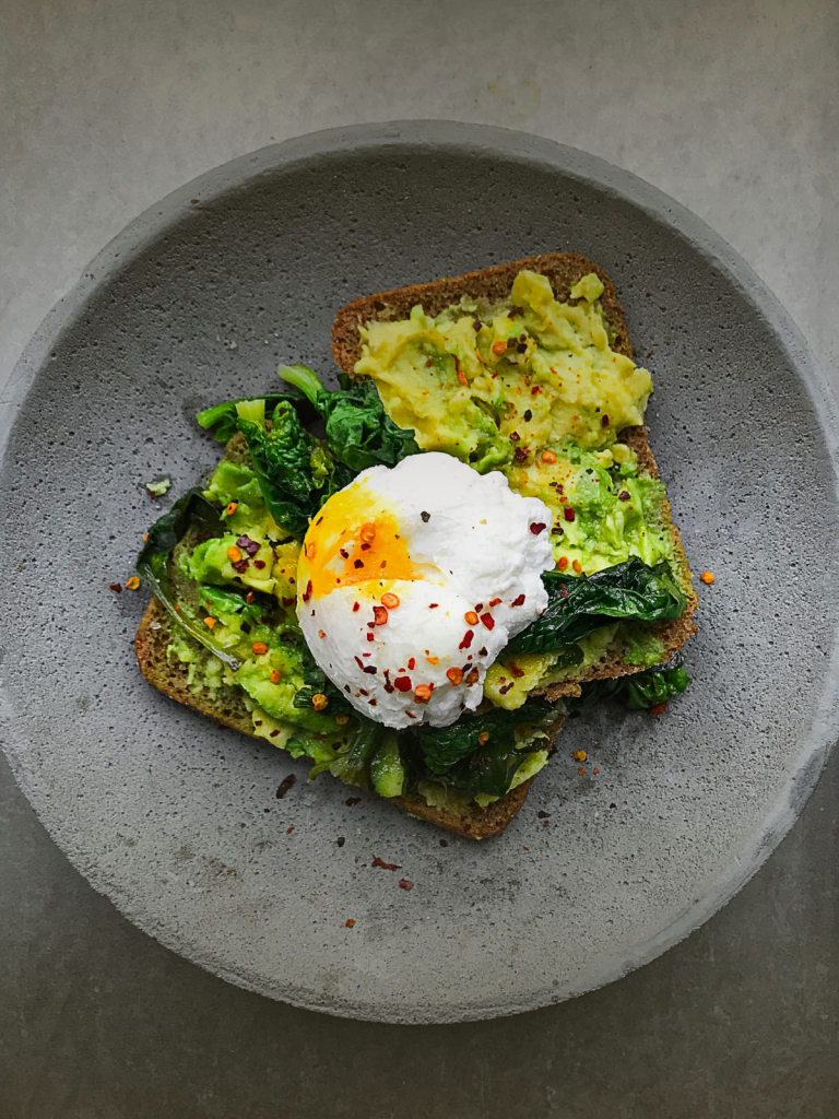 Top view image of classic avocado, kale and poached egg on toast. Recipe can be found on Boxwood & Bay's website.