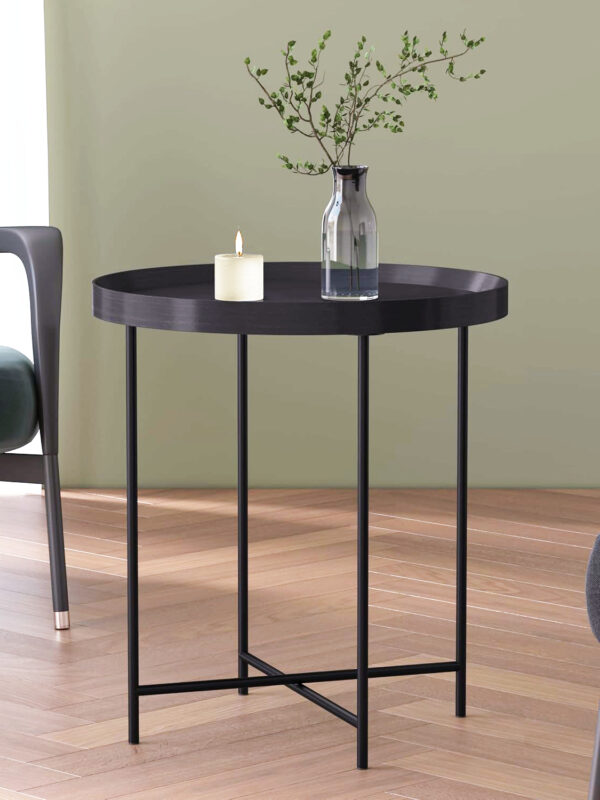 Round black lacquered side table styled beside armchair in modern heritage interior