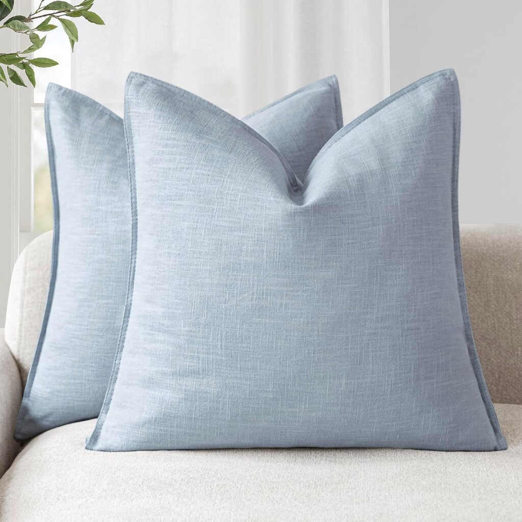 Image of a set of two Light Blue Linen Look Cushions on a sofa. Please note, the item is for the cushion covers only, cushion pad is not included. Available to buy from Amazon.