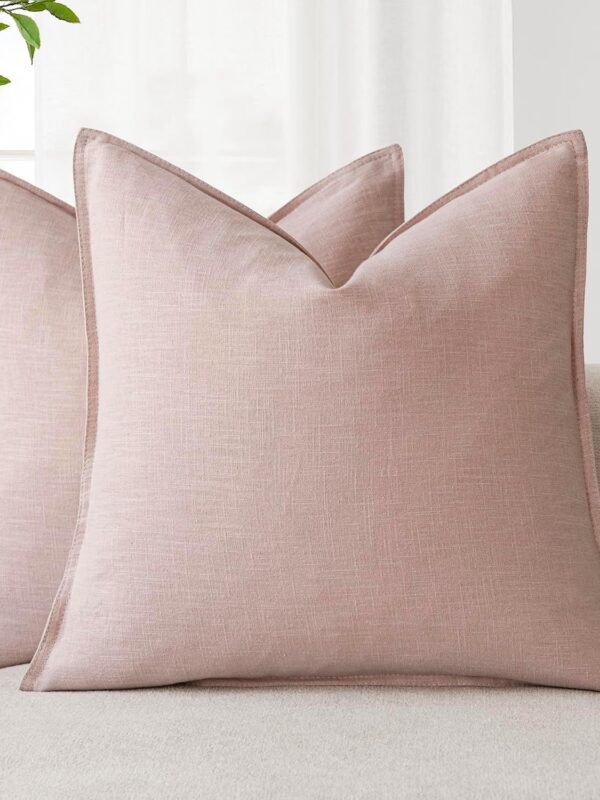 Image of a set of two Pink Linen Look Cushions on a sofa. Please note, the item is for the cushion covers only, cushion pad is not included. Available to buy from Amazon.
