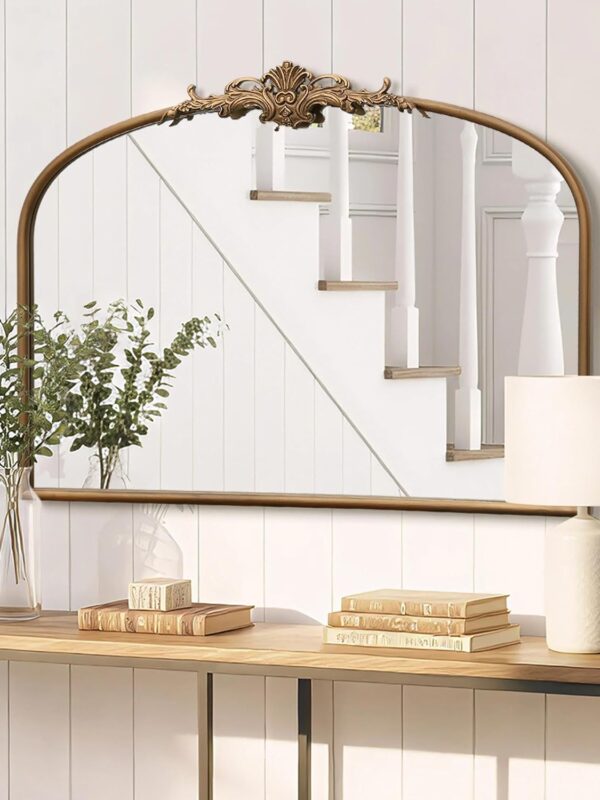 Gold French Baroque over mantel ornate mirror with arched top and decorative crest detail above a fireplace console